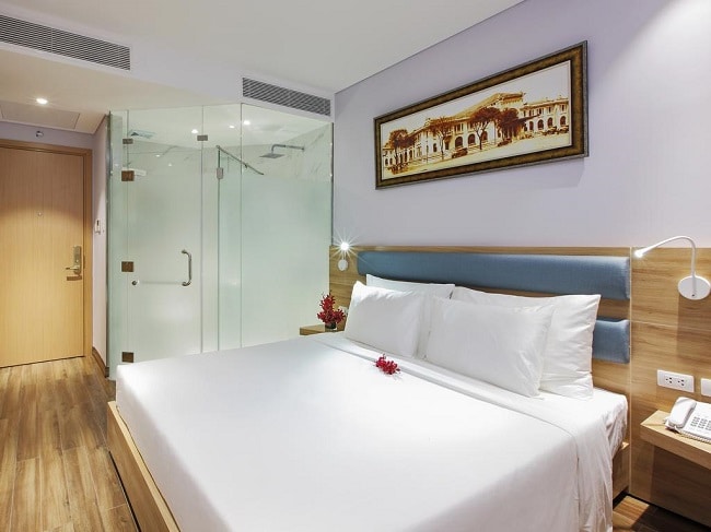 Góc phòng tắm sạch sẽ với gương lớn và đồ amenity gọn gàng.